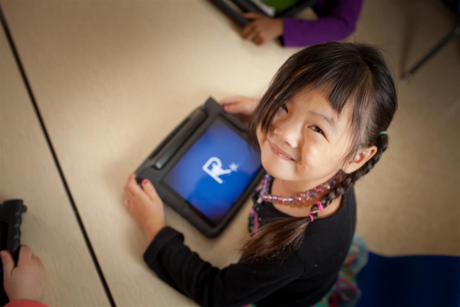 girl holding ipad and looking at camera girl holding ipad and looking at camera